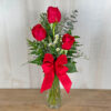 3 red roses in a vase with greens