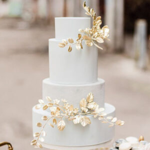 This four-tier wedding cake is a luxurious and glamorous statement piece for your special day. The cake is covered in gold leaf, which gives it a stunning metallic shine.