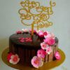 A decadent chocolate glazed cake adorned with delicate icing flowers