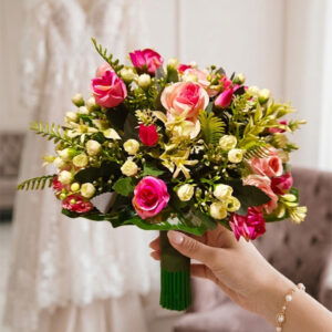 Beautifully layered with dense green ferns, broad-leaf foliage, and petite ivory buds.